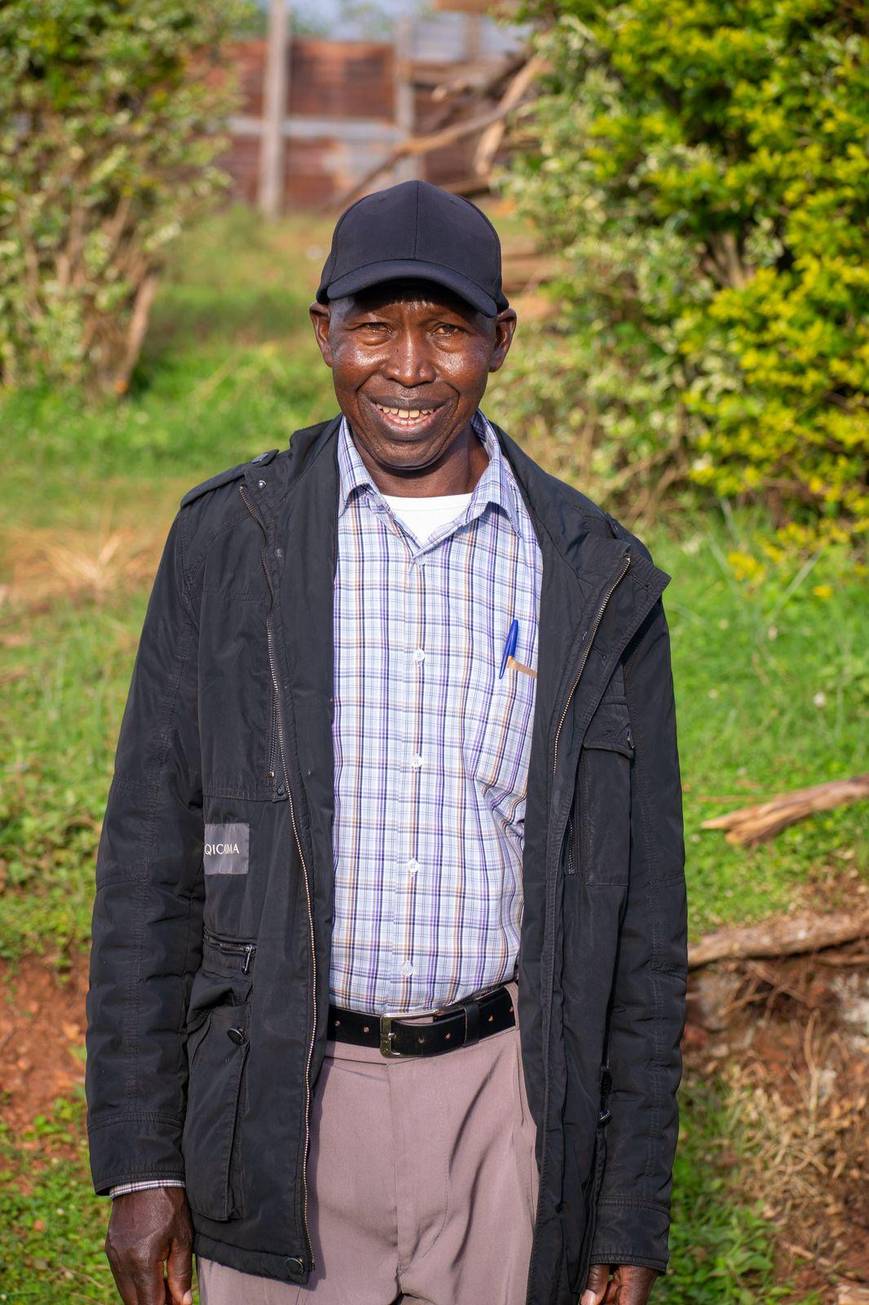 Andrew Kongo Ogechi standing outdoors in a black jacket over a checked shirt, smiling