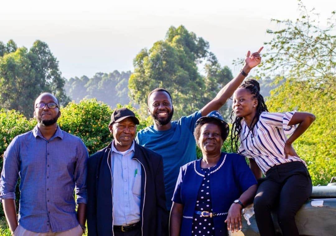 Andrew with four family members standing together outdoors among trees