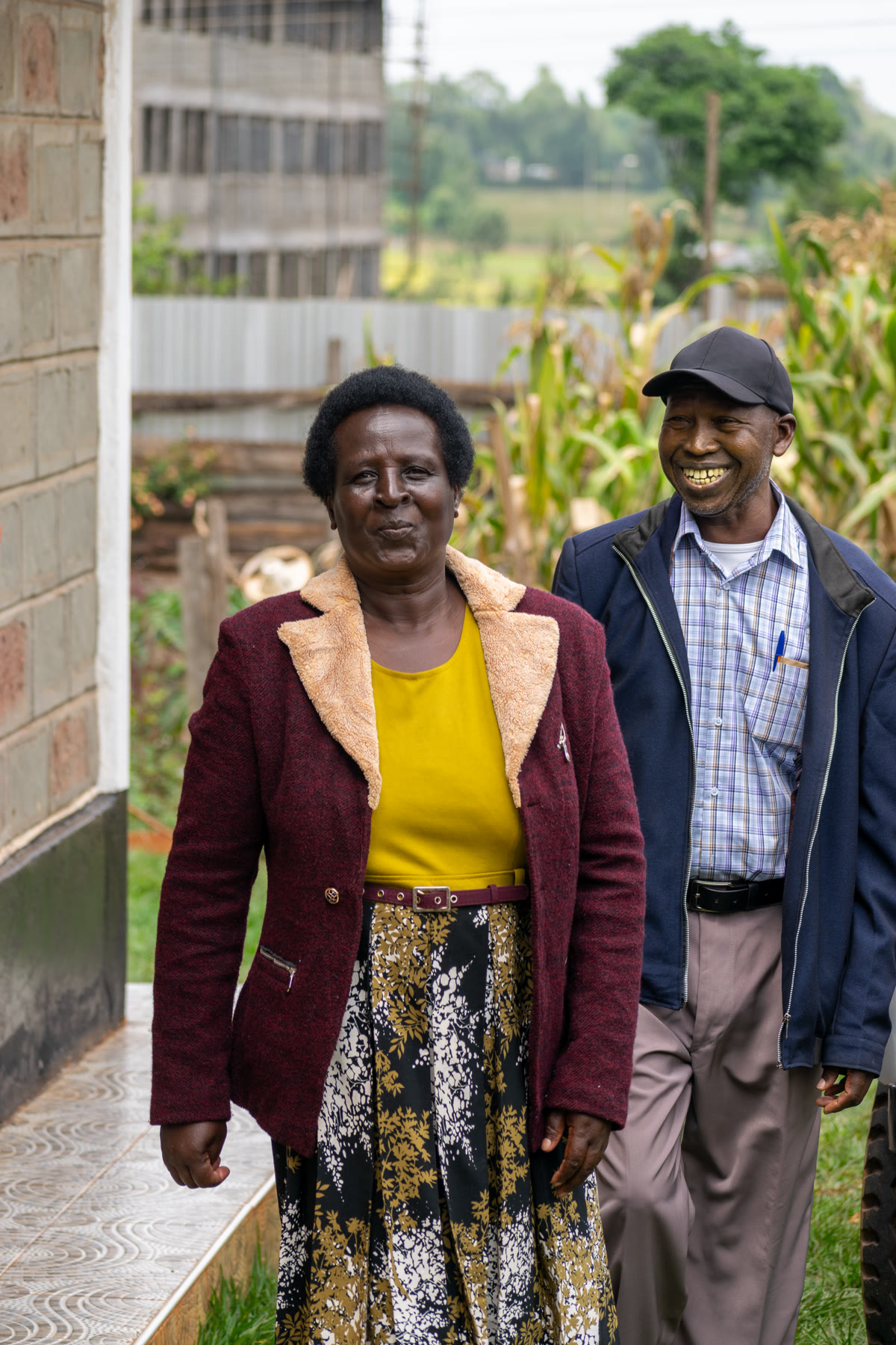 Andrew smiling beside a woman outside a house.