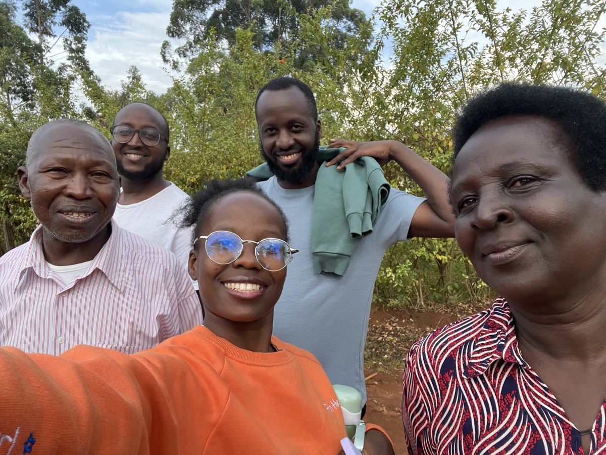 Andrew and four other people smiling for a selfie outdoors.